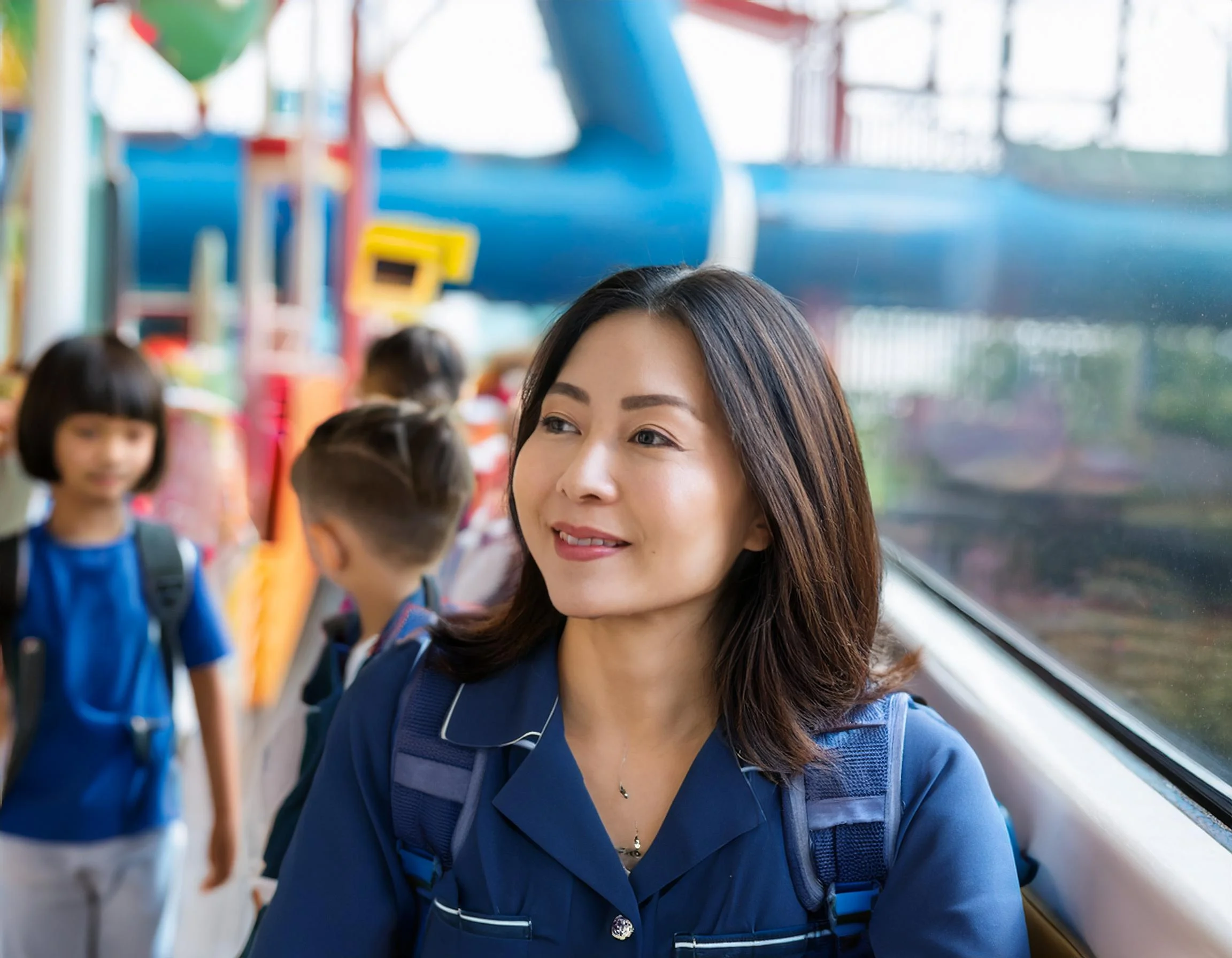 A female Nanny from Philippine in sea world looking over young child 6 years old in line