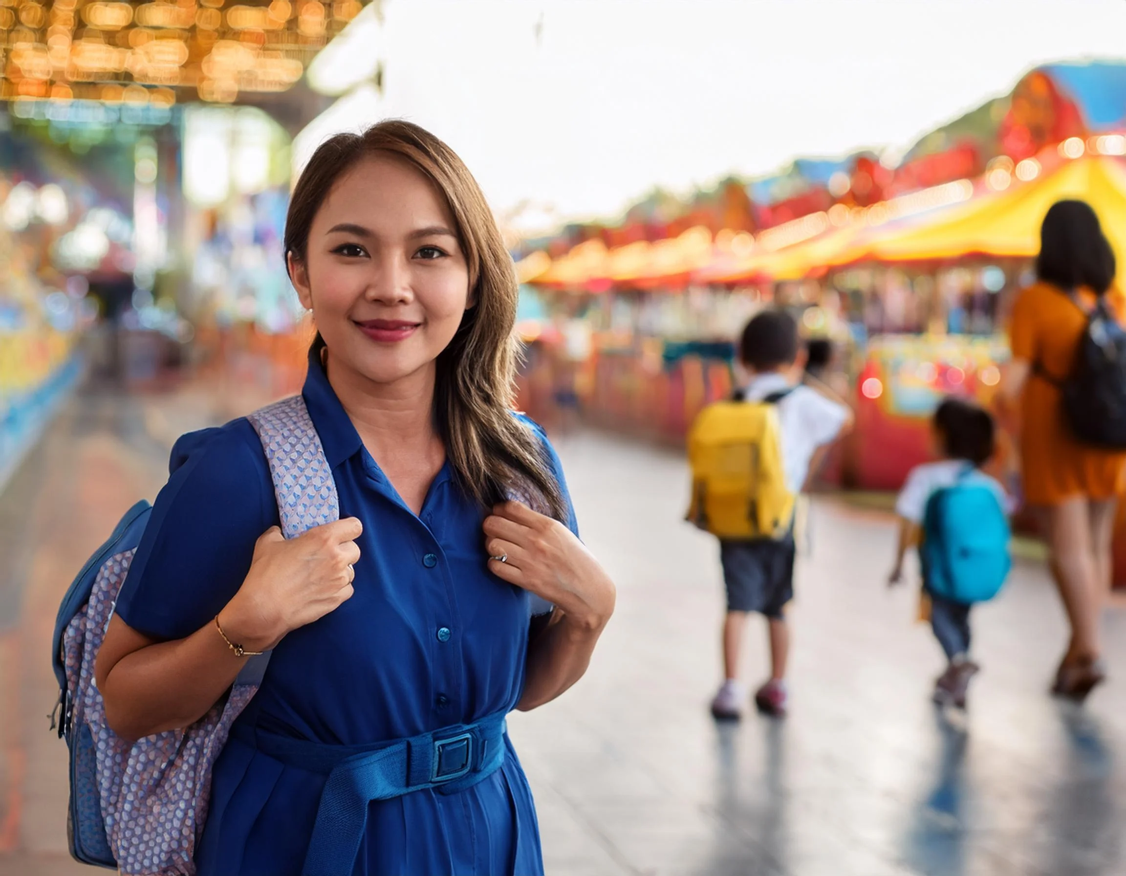 Female Filipino Nanny in Navy Blue Scrub with a backpack with a child in a queue of an amu